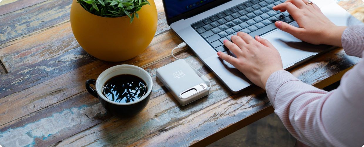 Powerbank 3mk incharge Genesis Qi 2.2 na drewnianym biurku obok otwartego laptopa i kawy
