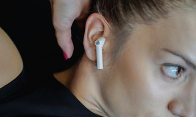 Kobieta ze słuchawkami ANC w trakcie ćwiczeń.