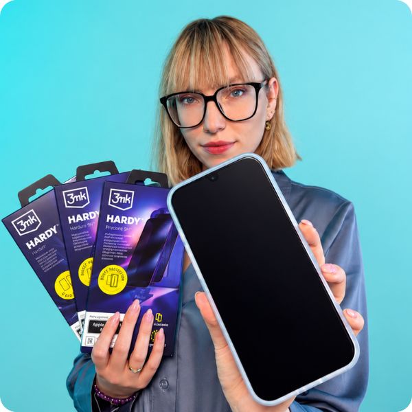 Kobieta w okularach trzyma iPhone 18 w etui hazy przydymionym white oraz trzy szkła ochronne 3mk Hardy w opakowaniach.